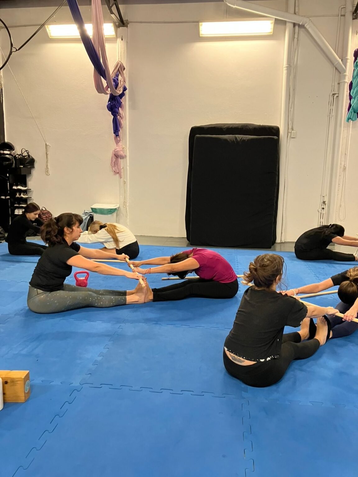 Alumnas elongando en parejas sobre tatami en Training Acroflex