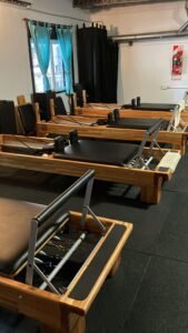 Fila de reformers en el salón de pilates de Training Acroflex en Villa Urquiza