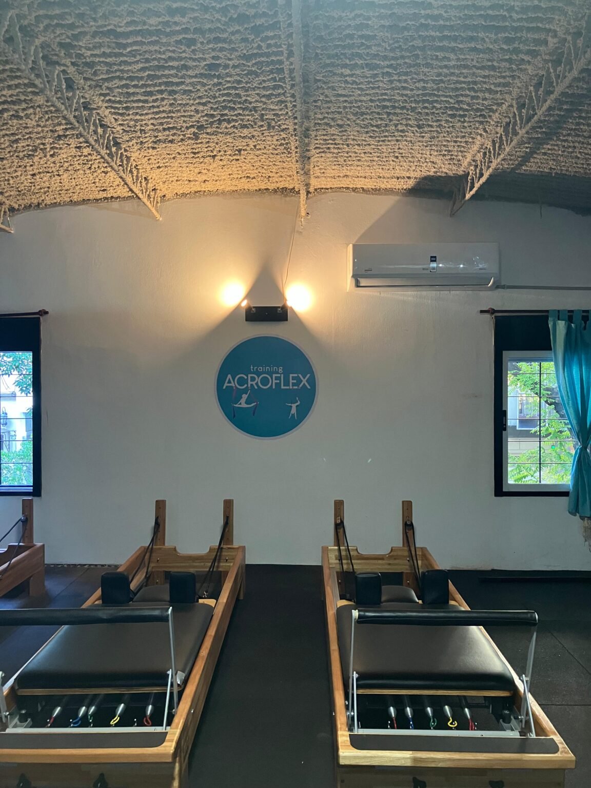 Reformers de pilates frente al logo de Training Acroflex, sede Villa Urquiza